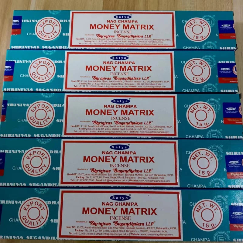 Multiple boxes of Satya Nag Champa Money Matrix incense on a wooden surface