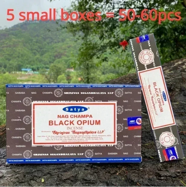 Box of Satya Nag Champa Black Opium incense with a single stick displayed outdoors.