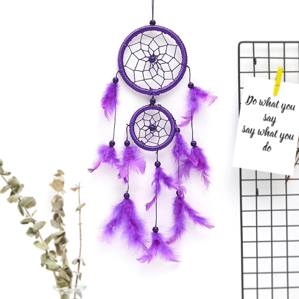 Purple dreamcatcher with feathers on a white background
