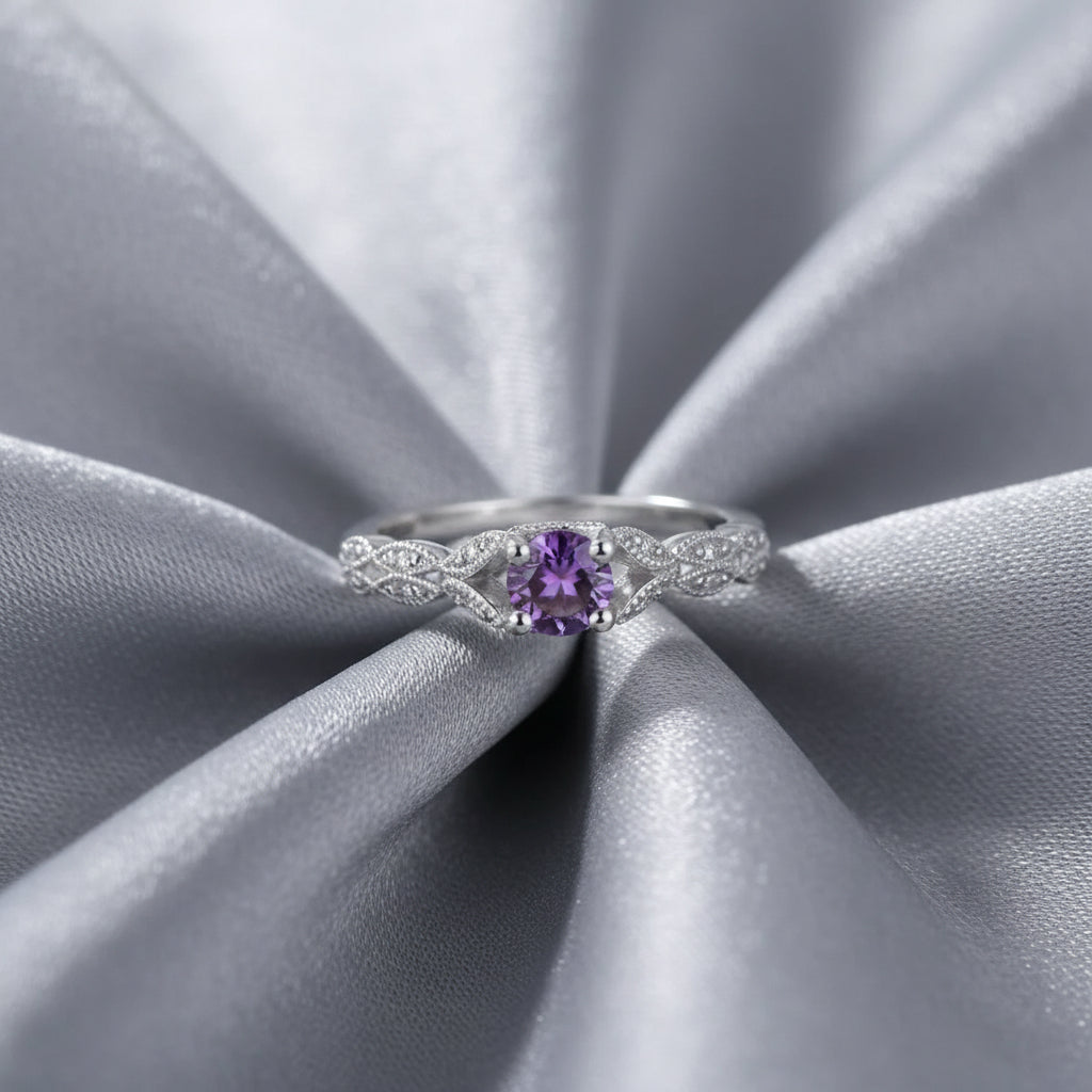 Silver ring with a purple gemstone on a white background