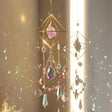 Decorative hanging crystal mobile with colorful stones against a soft background