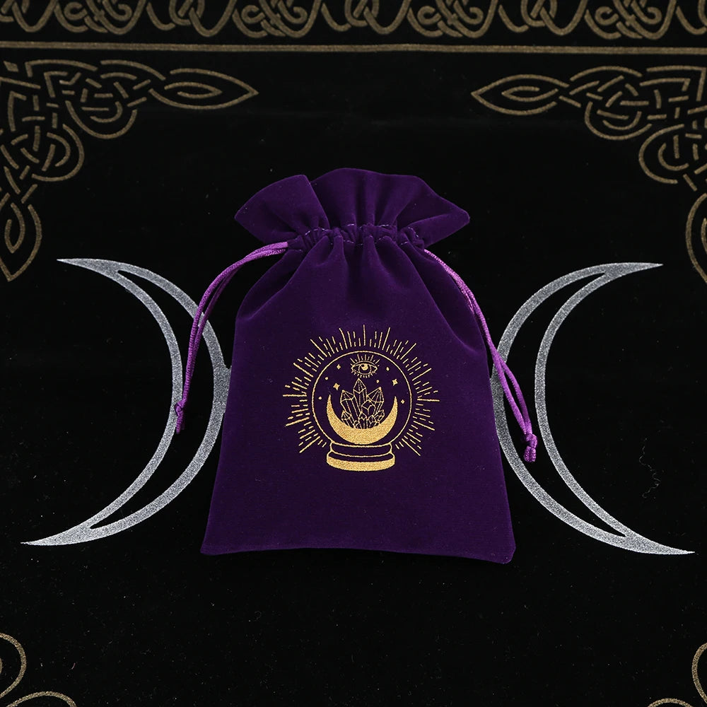 Purple velvet drawstring bag with gold emblem on a black background with white crescent moons.