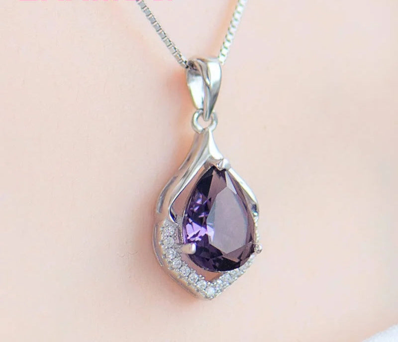 Purple teardrop pendant necklace on a soft pink background with 'YAAMel' branding.
