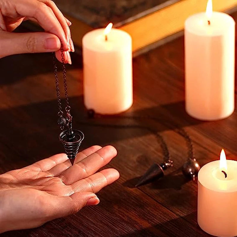 Person holding a pendulum over their palm with candles in the background
