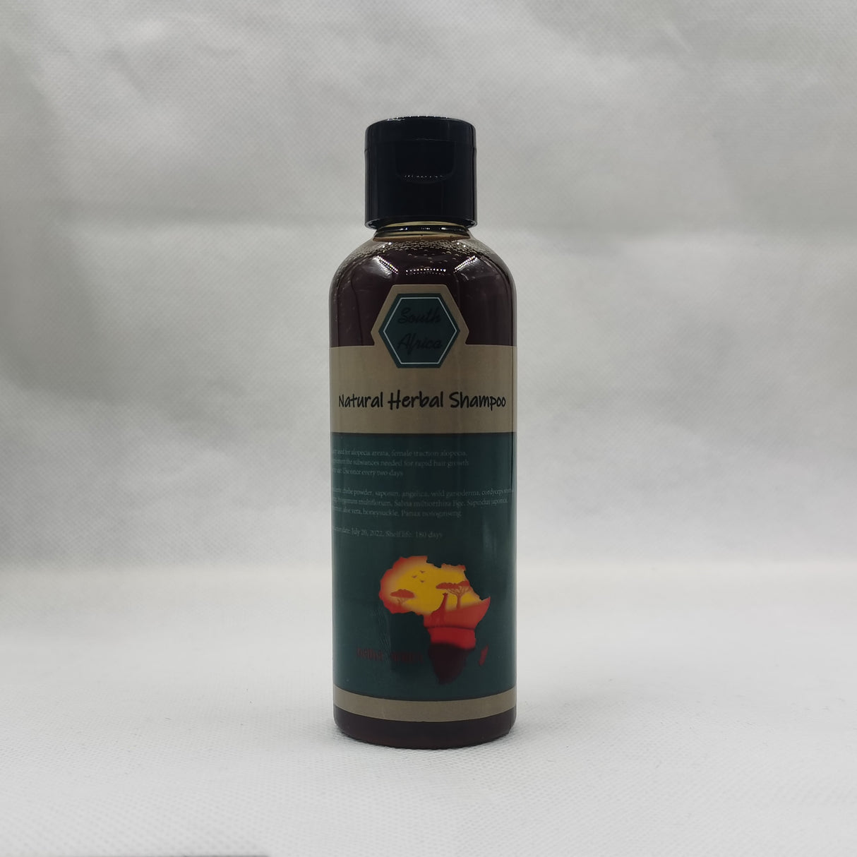 Bottle of natural herbal shampoo on a gray background