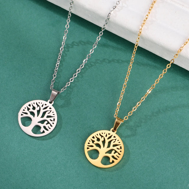 Two tree-shaped pendants on chains against a teal background
