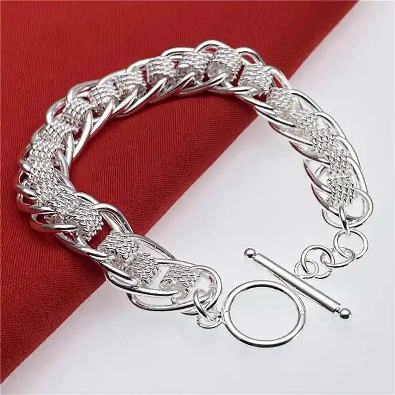 Silver bracelet with intricate design on a red and white background