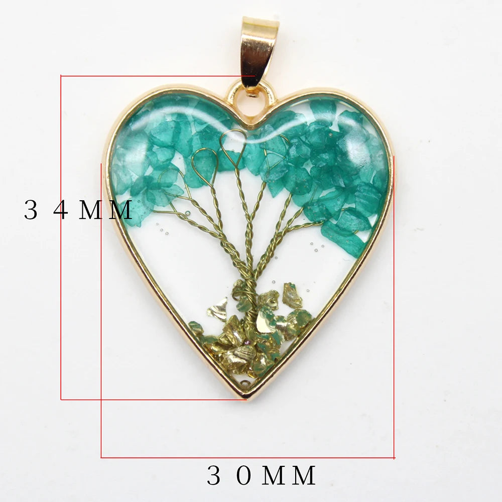 Heart-shaped pendant with green stones and gold frame, measurements indicated.
