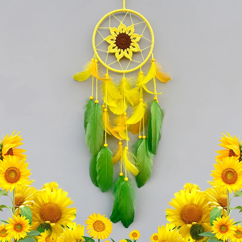 Yellow dreamcatcher with green feathers surrounded by sunflowers on a gray background
