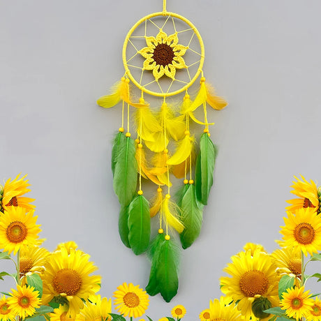 Yellow dreamcatcher with green feathers surrounded by sunflowers on a gray background