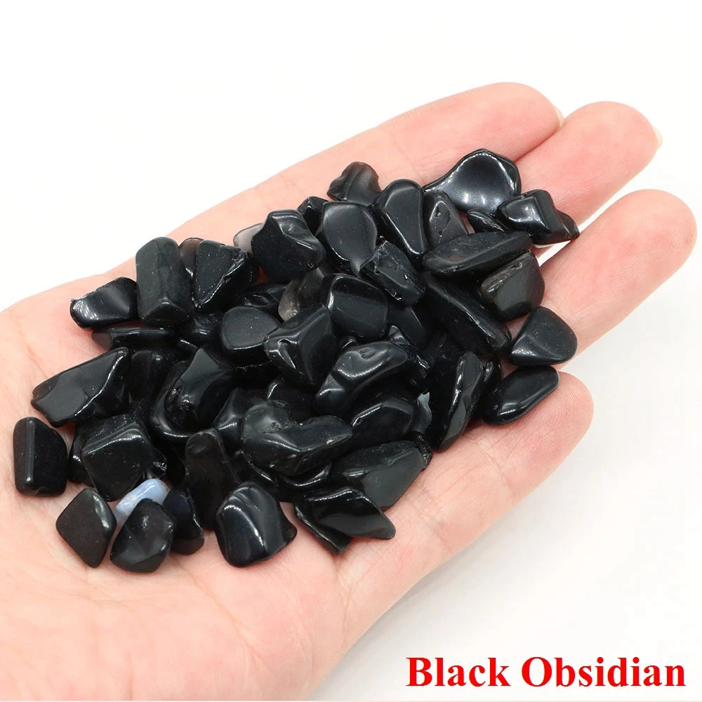Hand holding black obsidian stones with 'Black Obsidian' text on a white background