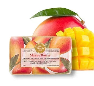 Mango Butter soap bar with packaging and a piece of mango on a white background