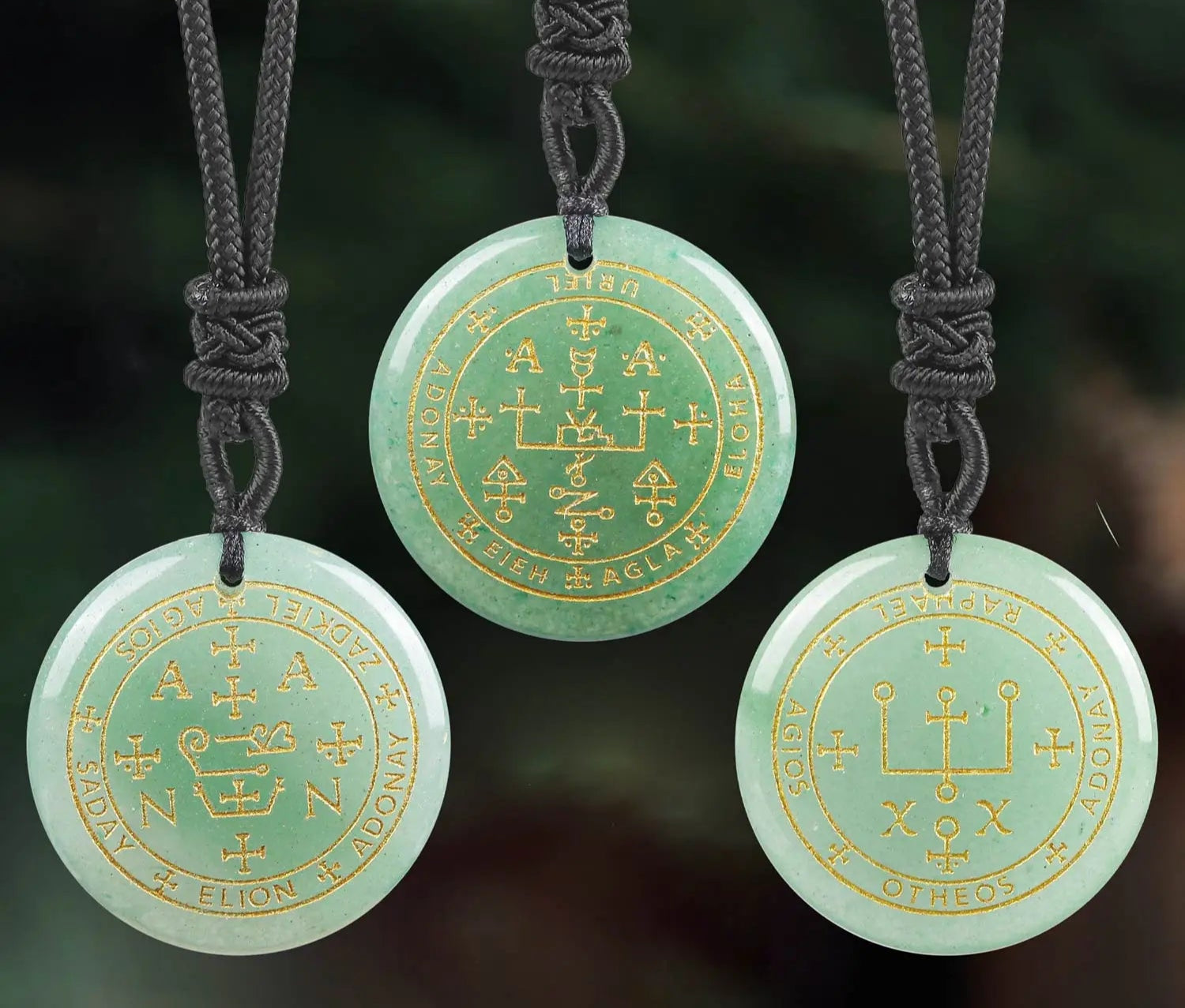 Three green necklaces with gold engravings on a blurred natural background