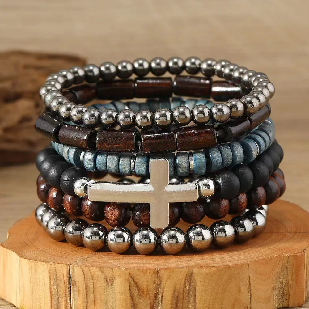 Stack of beaded bracelets with a cross charm on a wooden stand