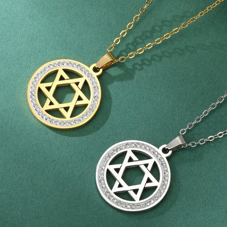 Two Star of David pendants, one gold and one silver, on a green background.