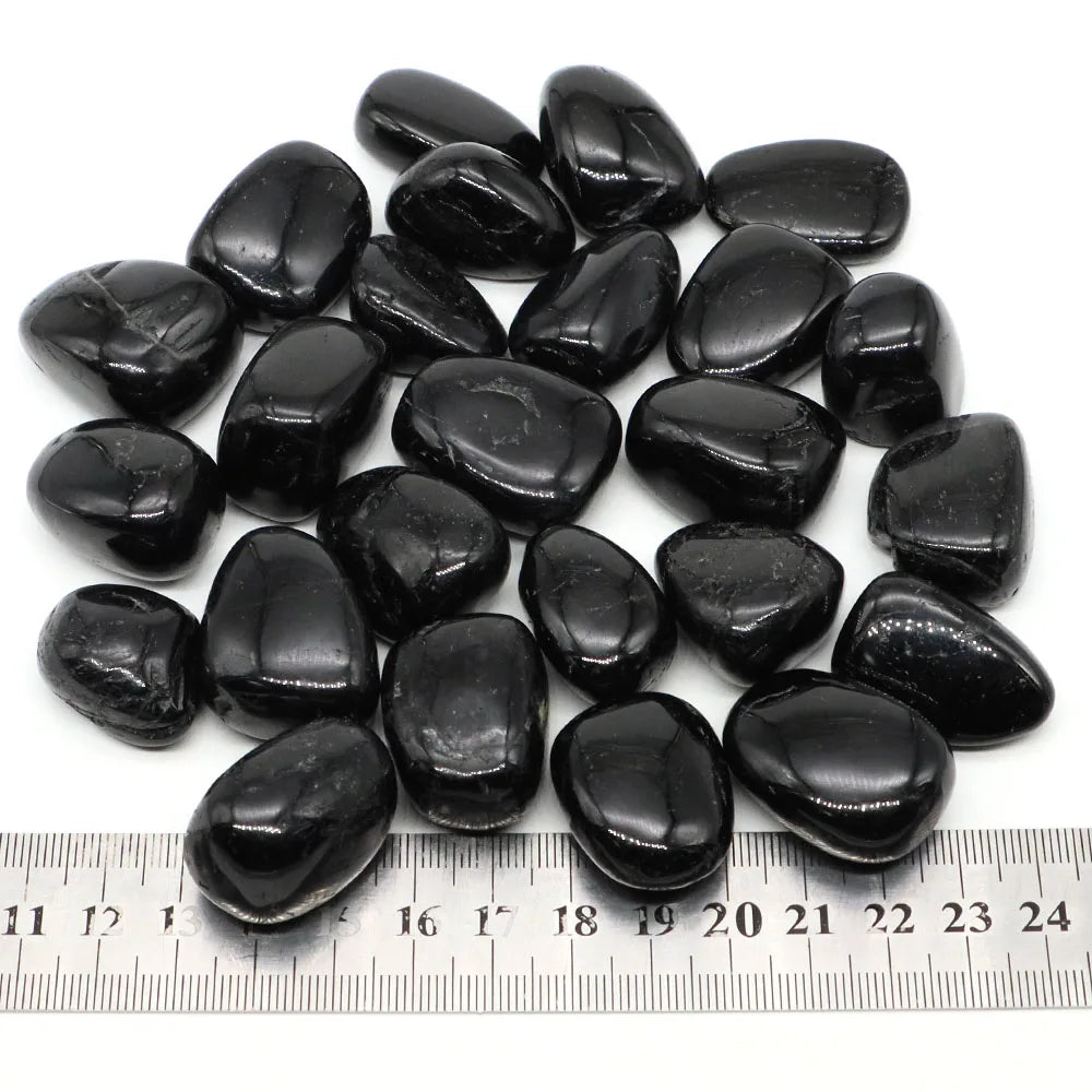 Black stones on a white background with a ruler for scale