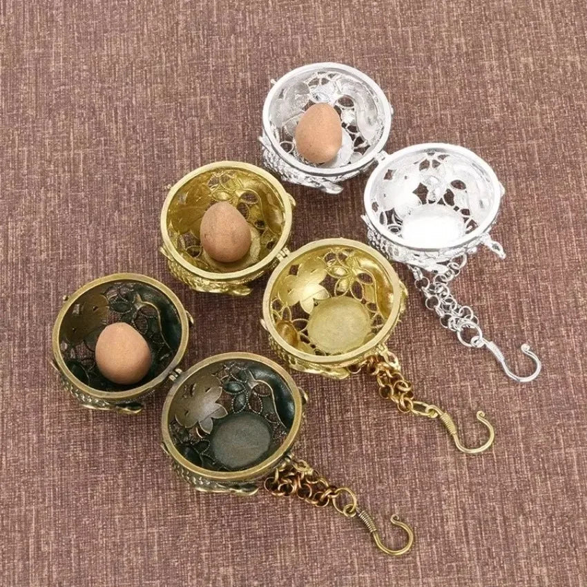 Decorative egg holders in gold and silver on a textured brown surface