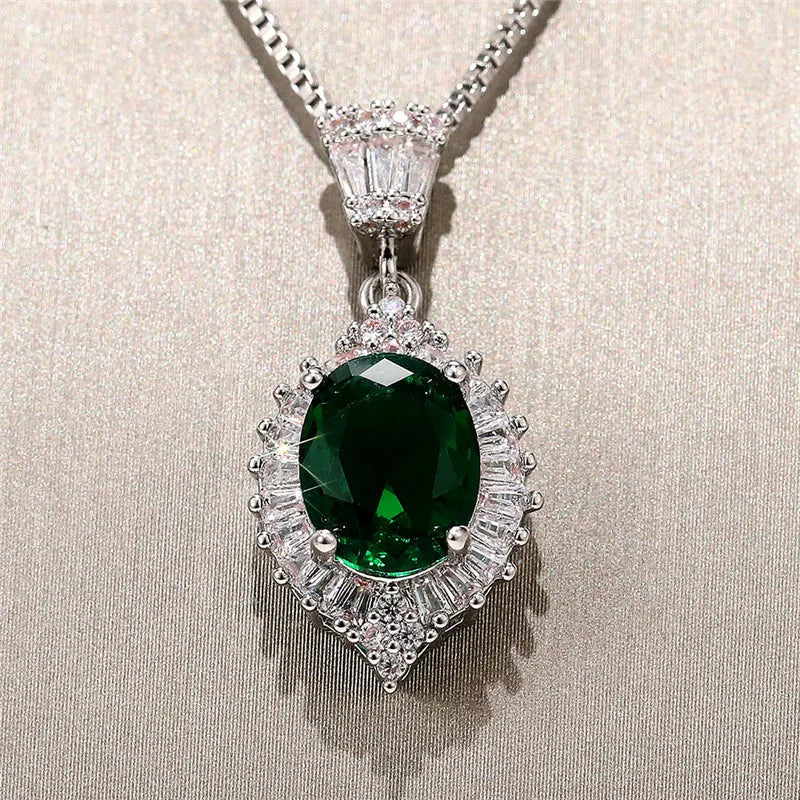 Emerald pendant necklace on a beige fabric background