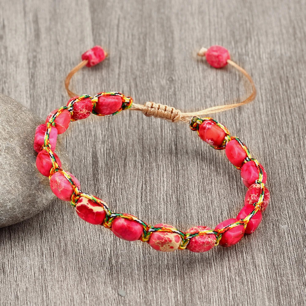 Bracelet with pink beads and a woven design on a wooden surface