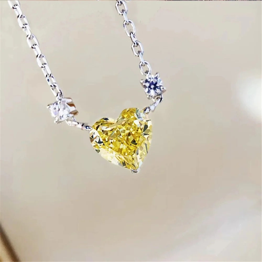 Heart-shaped yellow gemstone necklace with silver chain on a blurred background