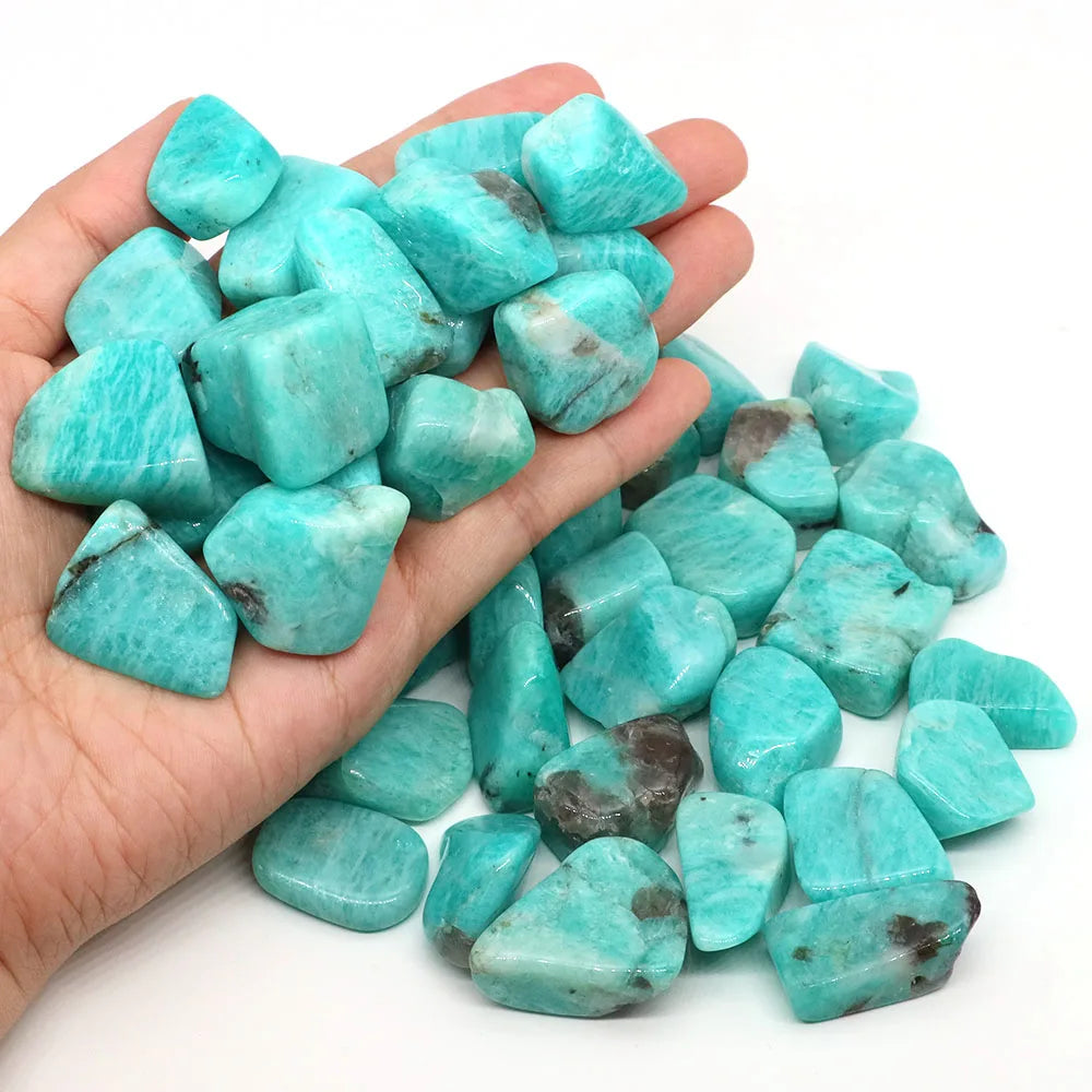 Turquoise stones held in a hand with a white background