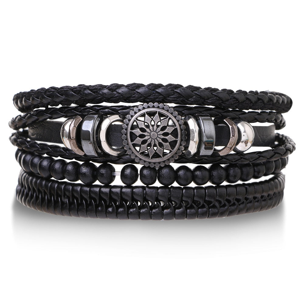 Stack of black leather and beaded bracelets with metal accents on a white background