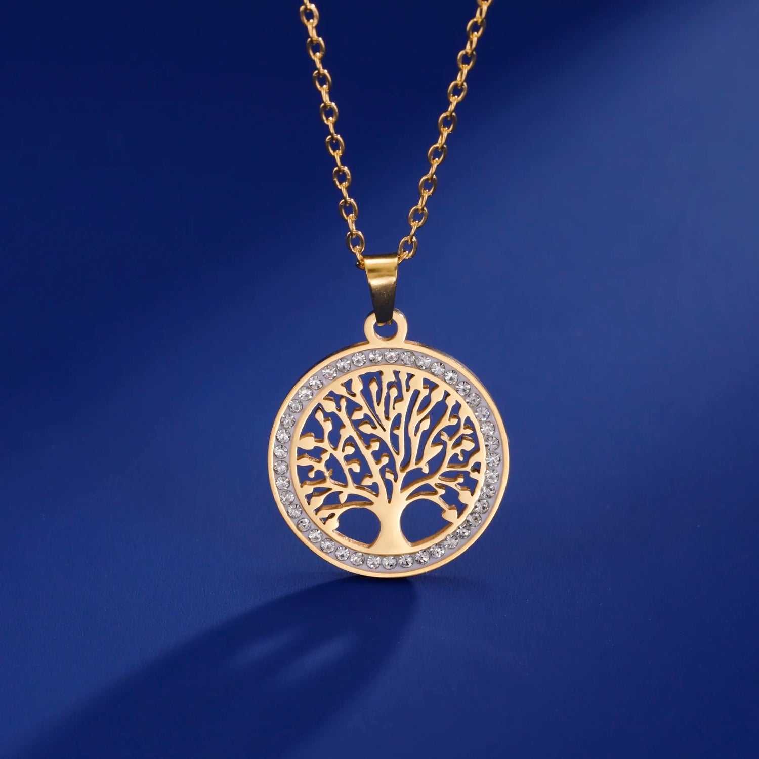 Gold necklace with a tree-of-life pendant on a blue background