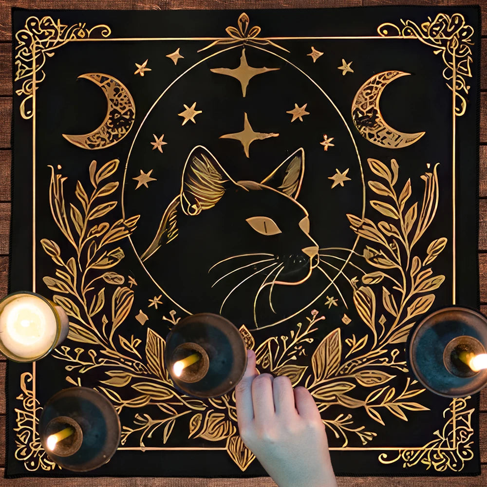Decorative mat with a gold cat design, candles, and a hand on a wooden surface