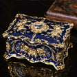 Decorative blue and gold box with intricate designs on a dark surface