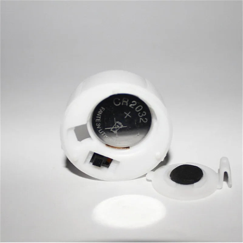 White battery holder with a CR2032 battery on a gray background