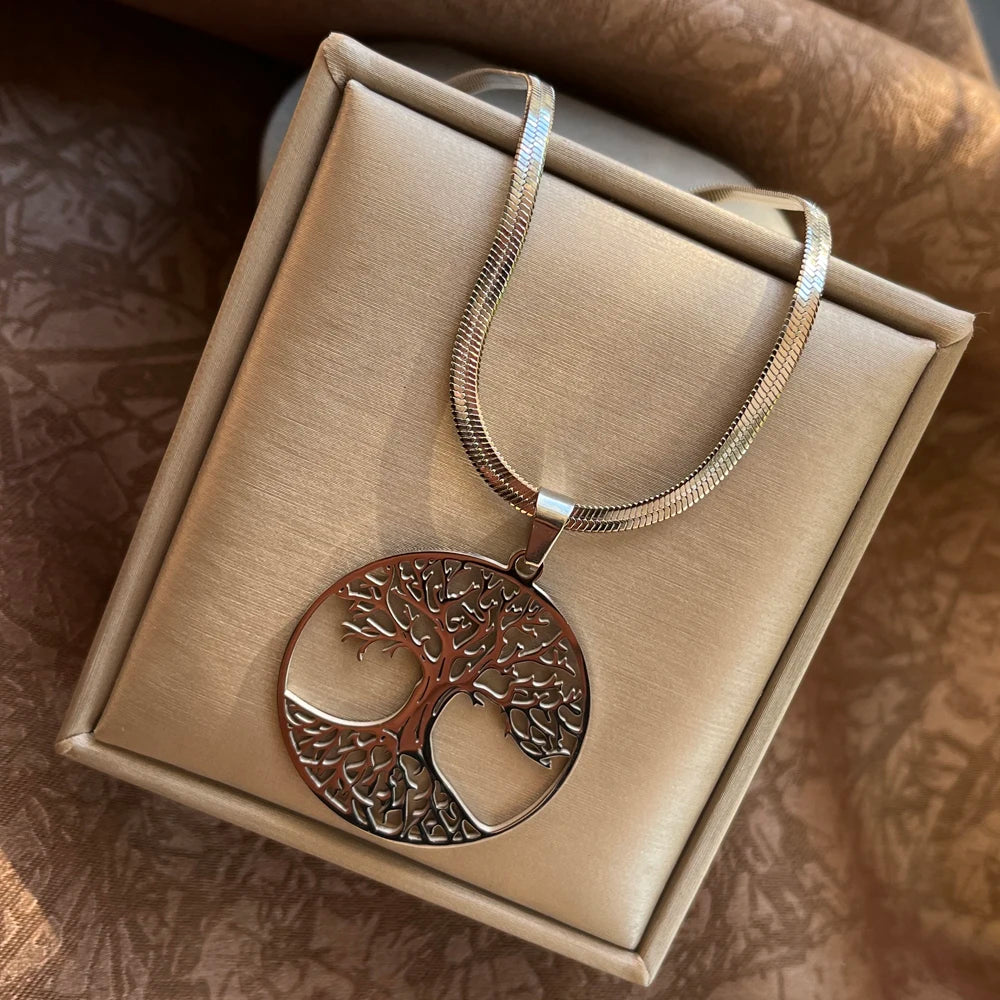Silver tree of life pendant necklace in a beige jewelry box on a textured brown surface