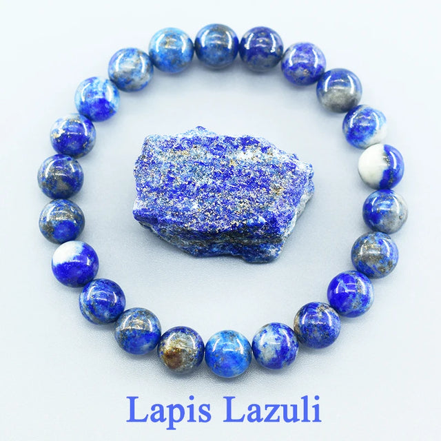 Lapis Lazuli beaded bracelet with a piece of raw lapis lazuli stone on a white background