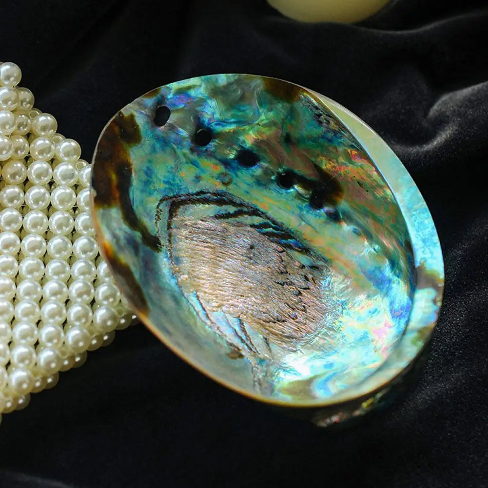 Abalone shell with pearls on a dark background