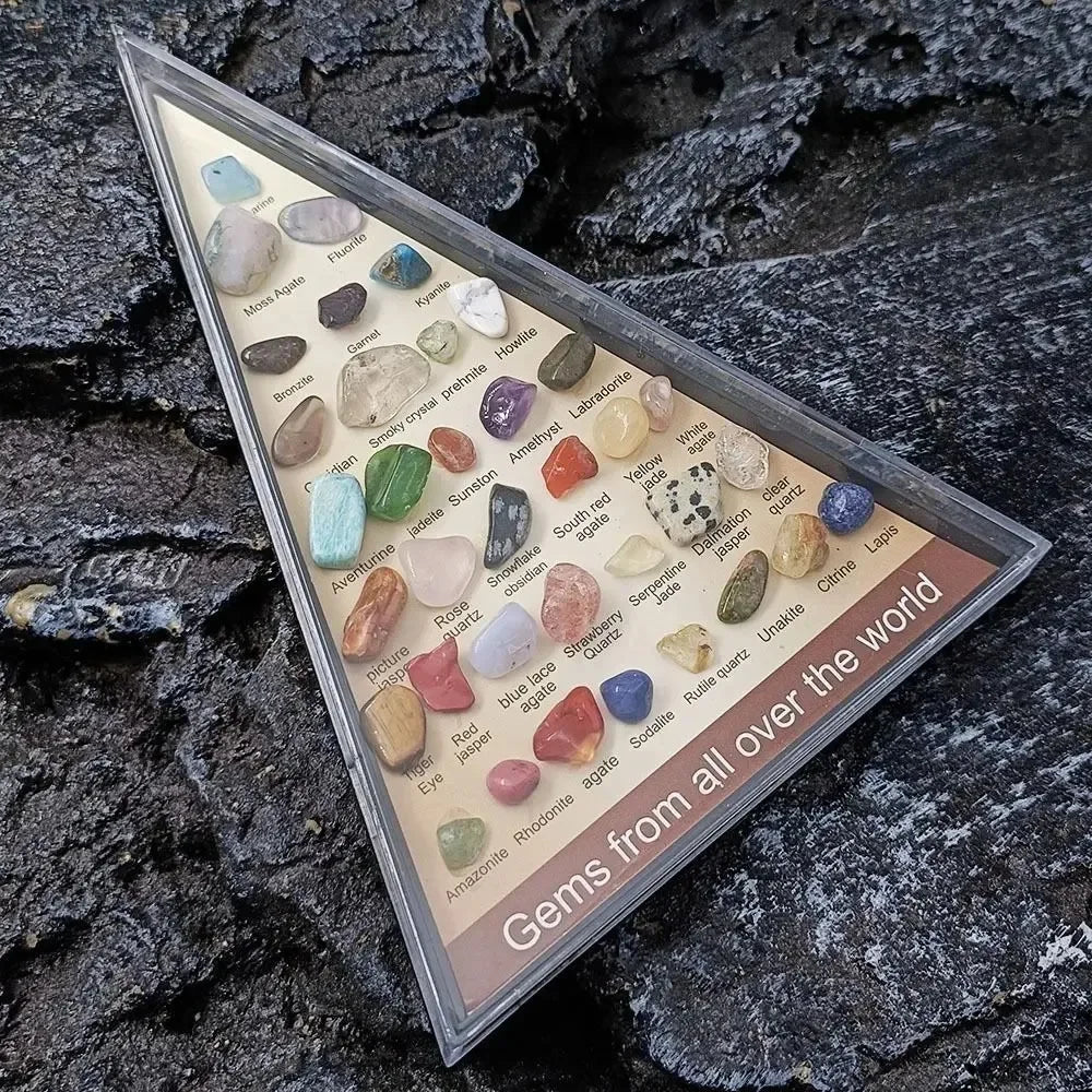 Collection of gemstones in a display case on a rocky background