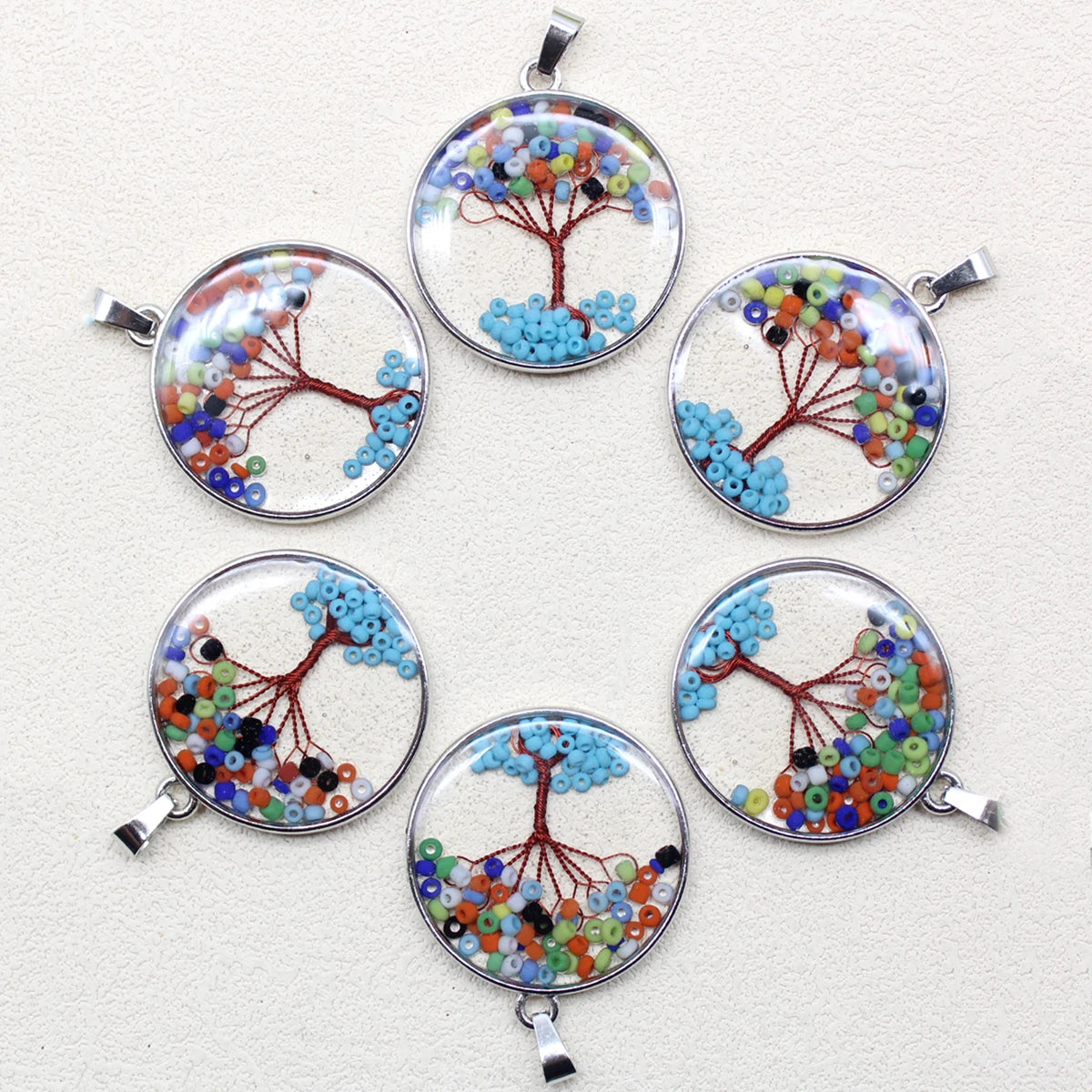 Set of six circular bead tree pendants on a white background