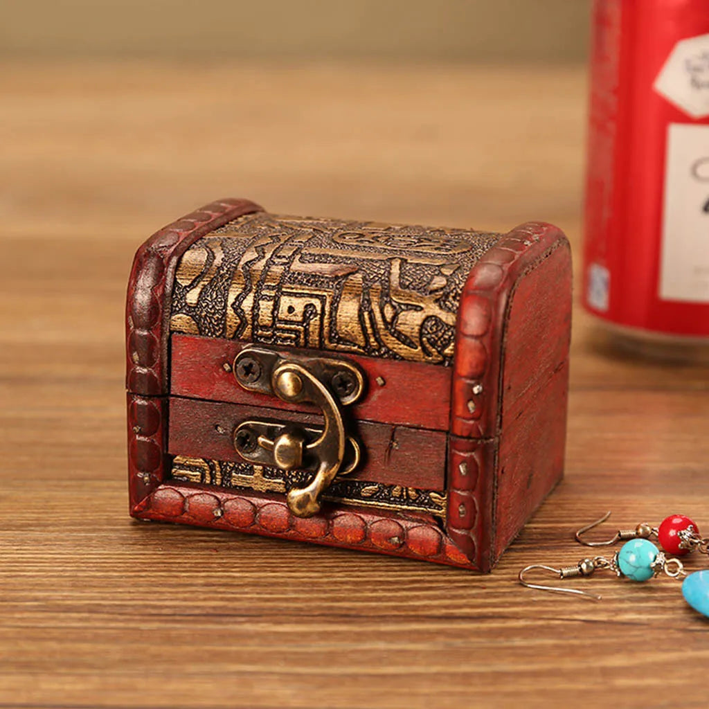 Vintage-style jewelry box with intricate designs on a wooden surface