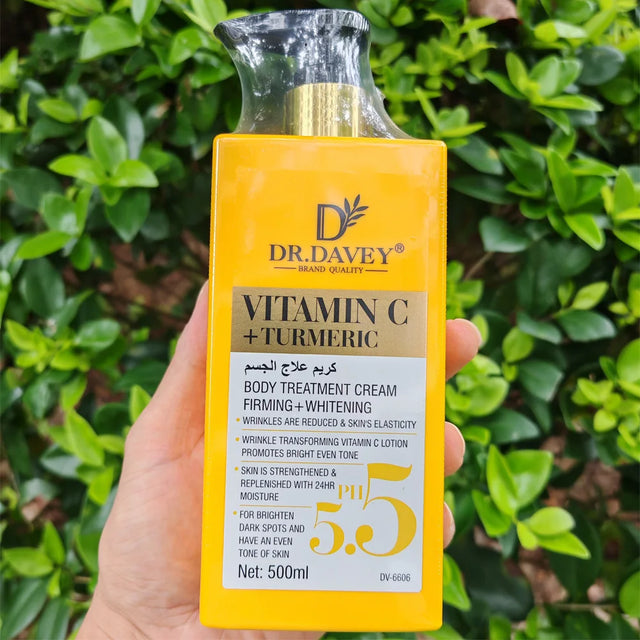 Dr. Davey Vitamin C + Turmeric body treatment cream bottle held in front of green foliage