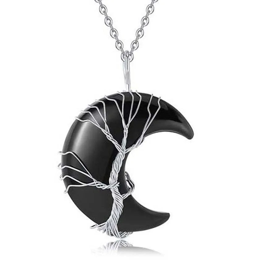 Black crescent moon pendant with silver tree design on a white background