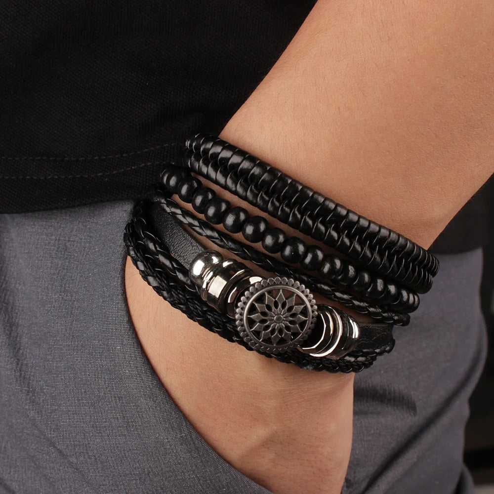 Close-up of a person's wrist wearing multiple black leather bracelets with metal accents.