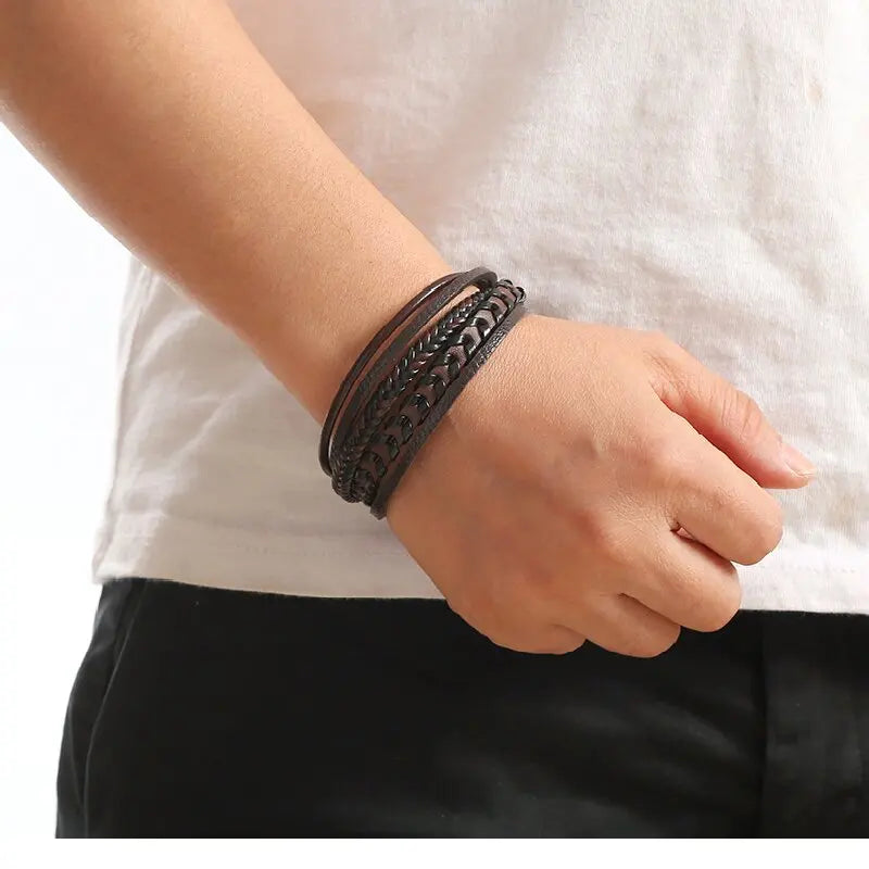 Person wearing a black leather bracelet on a white background