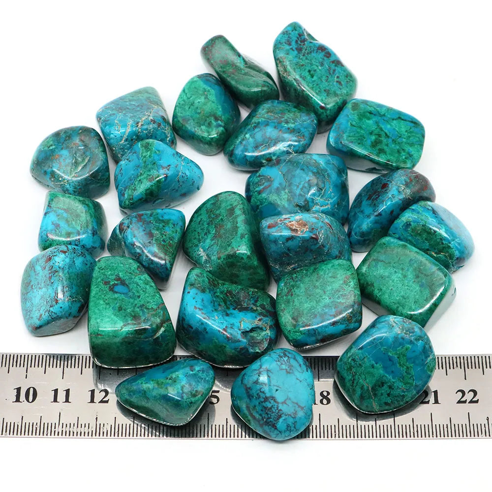 Turquoise stones with a ruler for scale on a white background