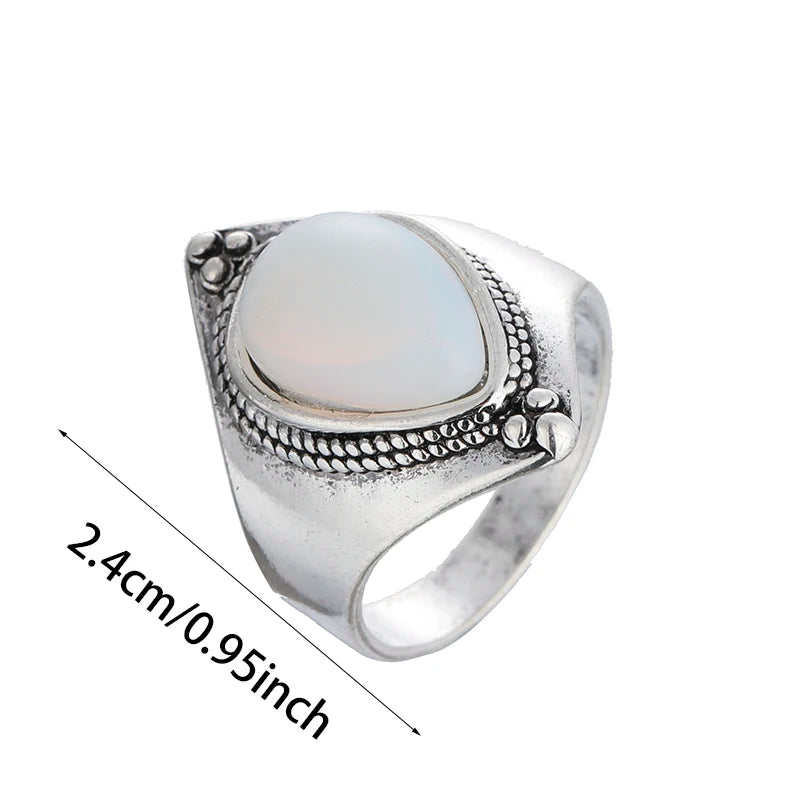 Silver ring with a white stone and measurements on a white background