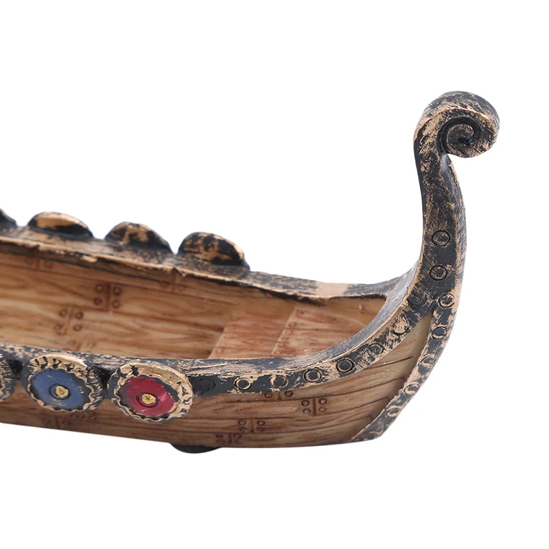 Wooden model of a Viking longship with decorative elements on a white background