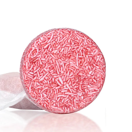 Pink bath bomb with sprinkles on a white background