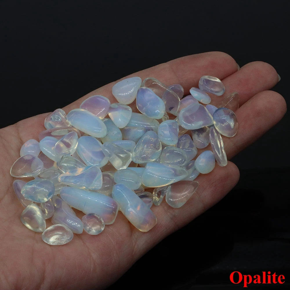 Hand holding a collection of opalite stones with a dark background