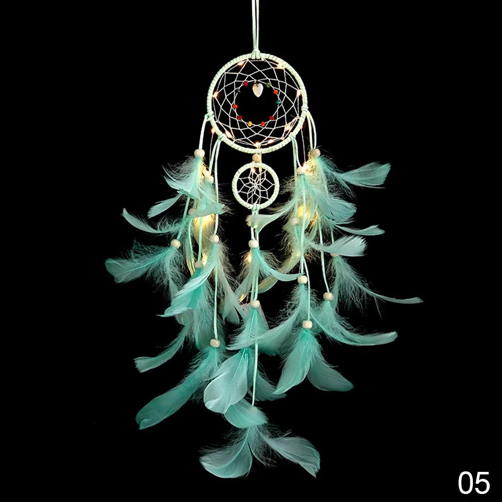 Turquoise feathered dreamcatcher with lights on a black background