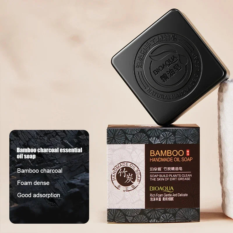 Two bamboo charcoal essential oil soaps with packaging on a beige background