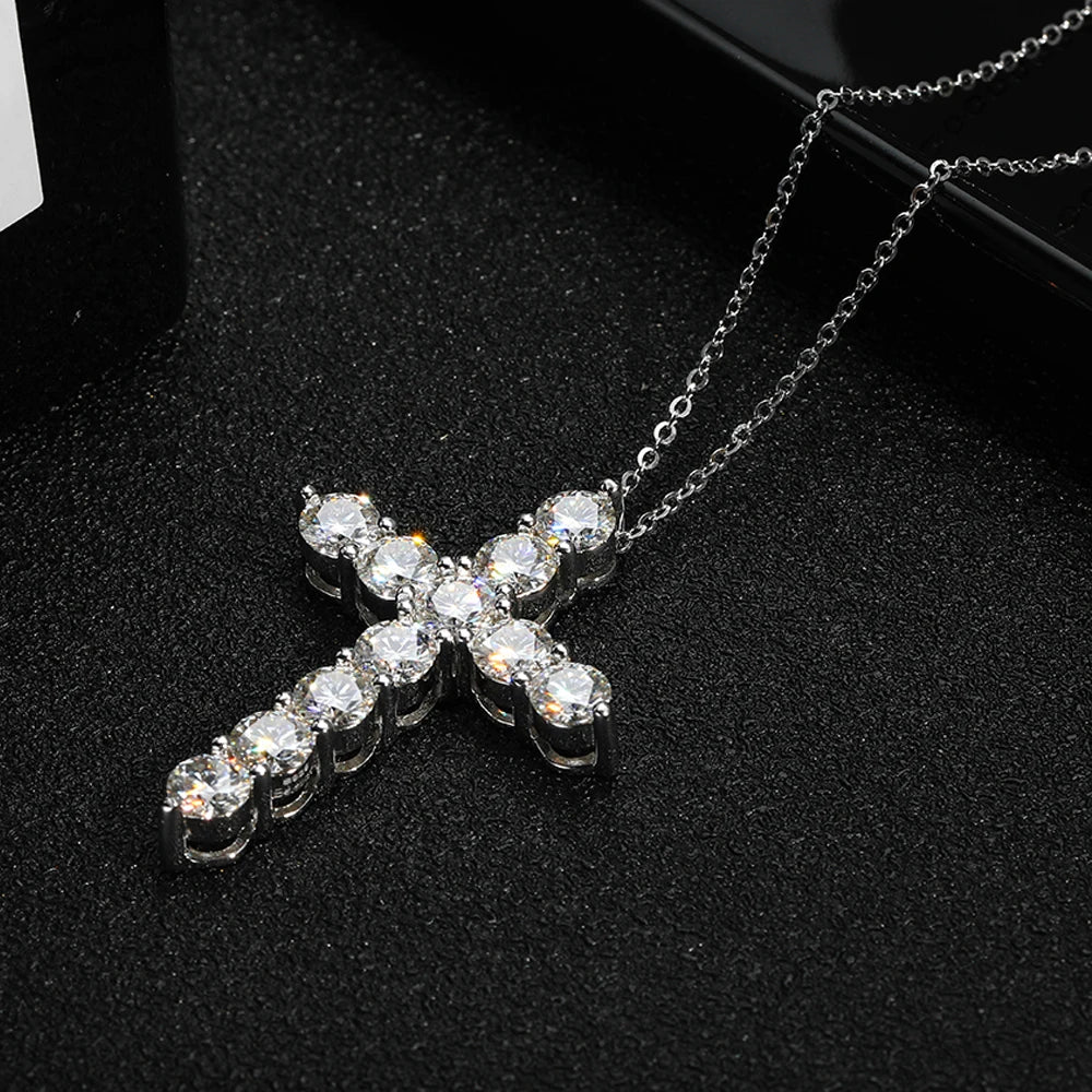 Silver cross necklace with clear stones on a black background
