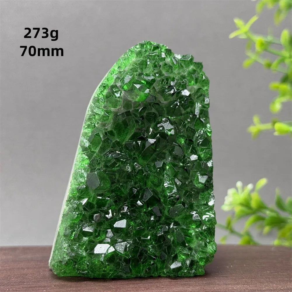 Green crystal rock on a wooden surface with a gray background