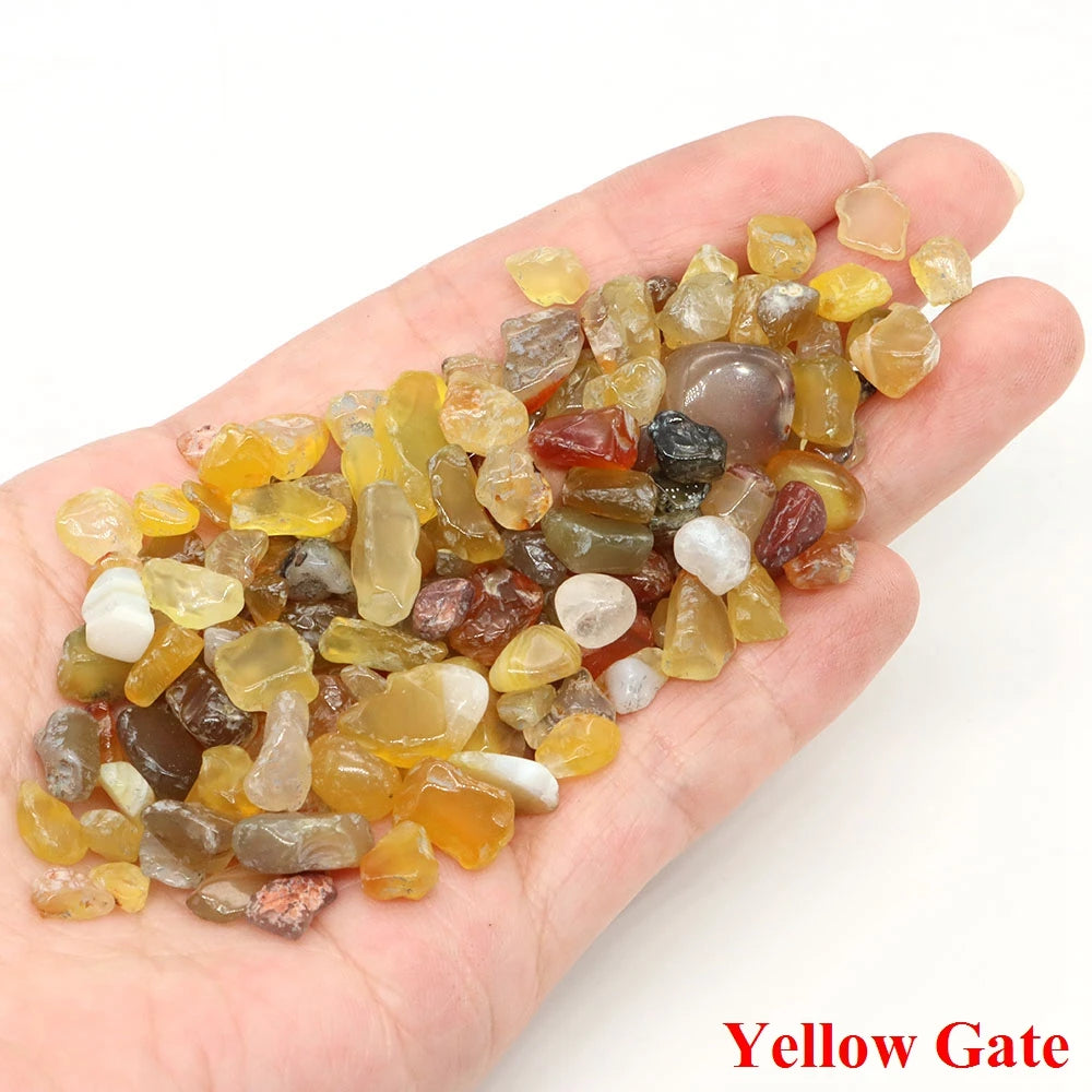 Hand holding a small pile of multicolored stones with 'Yellow Gate' branding.